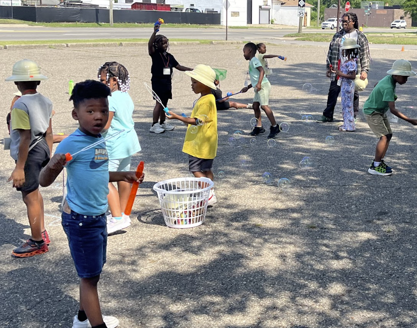 Campers playing with bubbles in the parking lot at Camp Ignite