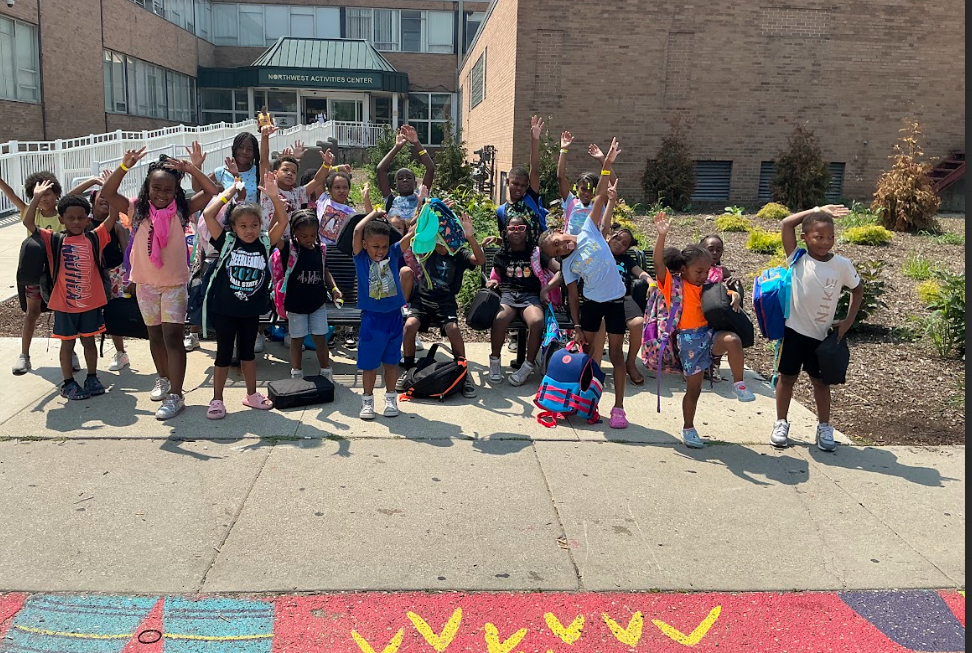 Camp Ignite group cheering with arms raised outside the Northwest Activities Center