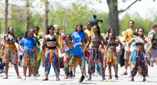 Group of young dancers performing in colorful cultural attire outdoors