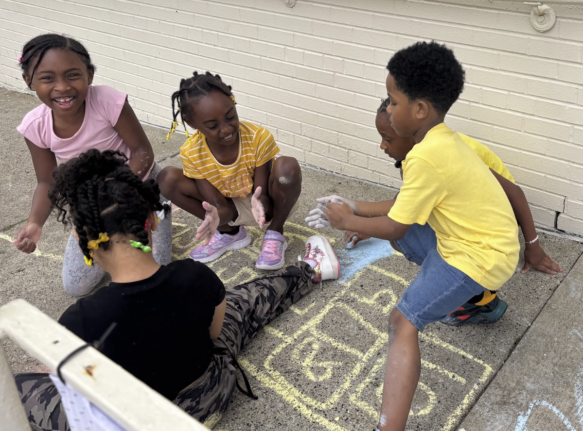 Camp Ignite kids laughing during a hopscotch game outdoors