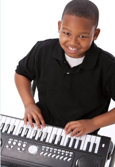 Smiling young boy playing an electronic keyboard