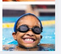 Smiling young swimmer with goggles and swim cap at the edge of the pool